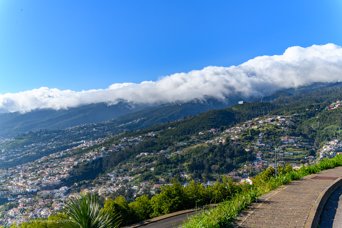 Wolken in den Bergen Funchals von Palheiro aus